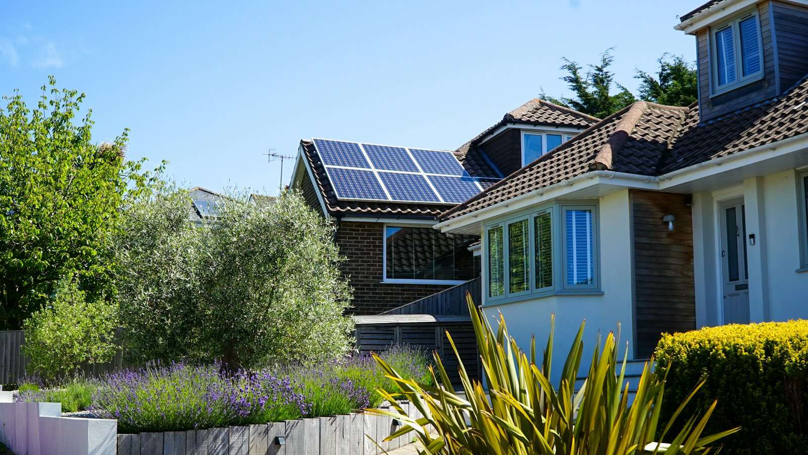 Casa con jardín y placas solares en el tejado