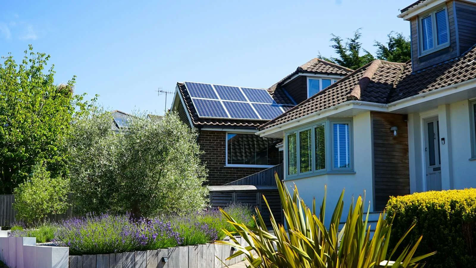 Casa con jardín y placas solares en el tejado